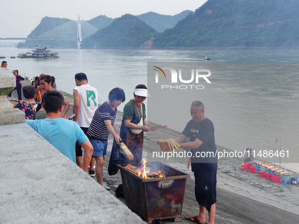 People are burning paper money to offer sacrifices to their ancestors during the Hungry Ghost Festival in Yichang, China, on August 16, 2024...