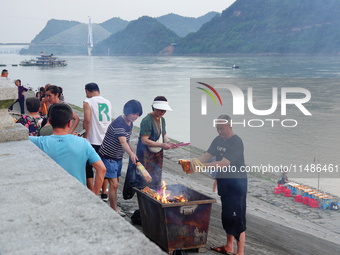 People are burning paper money to offer sacrifices to their ancestors during the Hungry Ghost Festival in Yichang, China, on August 16, 2024...