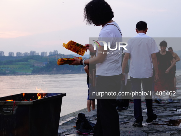 People are burning paper money to offer sacrifices to their ancestors during the Hungry Ghost Festival in Yichang, China, on August 16, 2024...