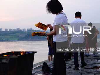 People are burning paper money to offer sacrifices to their ancestors during the Hungry Ghost Festival in Yichang, China, on August 16, 2024...