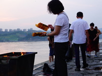 People are burning paper money to offer sacrifices to their ancestors during the Hungry Ghost Festival in Yichang, China, on August 16, 2024...