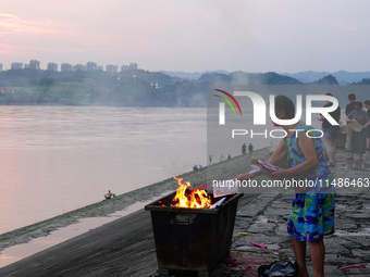 People are burning paper money to offer sacrifices to their ancestors during the Hungry Ghost Festival in Yichang, China, on August 16, 2024...