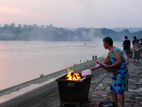 People are burning paper money to offer sacrifices to their ancestors during the Hungry Ghost Festival in Yichang, China, on August 16, 2024...