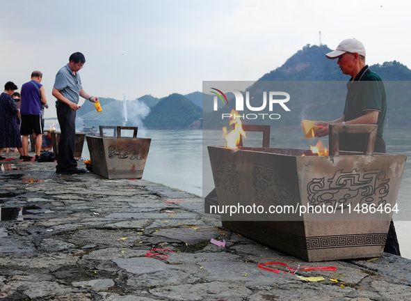 People are burning paper money to offer sacrifices to their ancestors during the Hungry Ghost Festival in Yichang, China, on August 16, 2024...