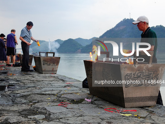 People are burning paper money to offer sacrifices to their ancestors during the Hungry Ghost Festival in Yichang, China, on August 16, 2024...