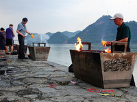 People are burning paper money to offer sacrifices to their ancestors during the Hungry Ghost Festival in Yichang, China, on August 16, 2024...