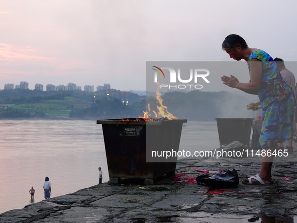 People are burning paper money to offer sacrifices to their ancestors during the Hungry Ghost Festival in Yichang, China, on August 16, 2024...