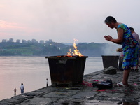 People are burning paper money to offer sacrifices to their ancestors during the Hungry Ghost Festival in Yichang, China, on August 16, 2024...