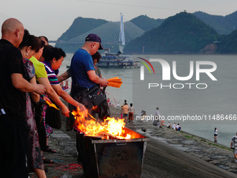 People are burning paper money to offer sacrifices to their ancestors during the Hungry Ghost Festival in Yichang, China, on August 16, 2024...