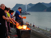 People are burning paper money to offer sacrifices to their ancestors during the Hungry Ghost Festival in Yichang, China, on August 16, 2024...