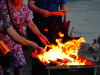 People are burning paper money to offer sacrifices to their ancestors during the Hungry Ghost Festival in Yichang, China, on August 16, 2024...