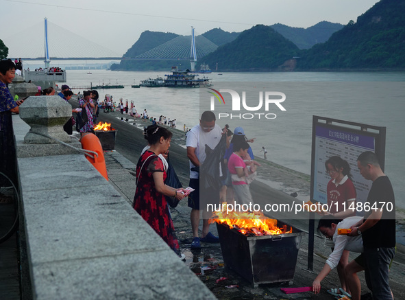 People are burning paper money to offer sacrifices to their ancestors during the Hungry Ghost Festival in Yichang, China, on August 16, 2024...