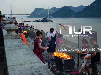 People are burning paper money to offer sacrifices to their ancestors during the Hungry Ghost Festival in Yichang, China, on August 16, 2024...