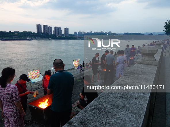 People are burning paper money to offer sacrifices to their ancestors during the Hungry Ghost Festival in Yichang, China, on August 16, 2024...