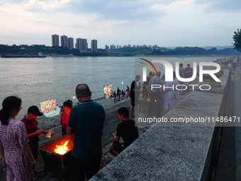 People are burning paper money to offer sacrifices to their ancestors during the Hungry Ghost Festival in Yichang, China, on August 16, 2024...