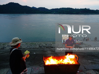 People are burning paper money to offer sacrifices to their ancestors during the Hungry Ghost Festival in Yichang, China, on August 16, 2024...