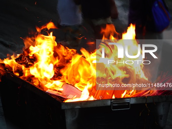 People are burning paper money to offer sacrifices to their ancestors during the Hungry Ghost Festival in Yichang, China, on August 16, 2024...