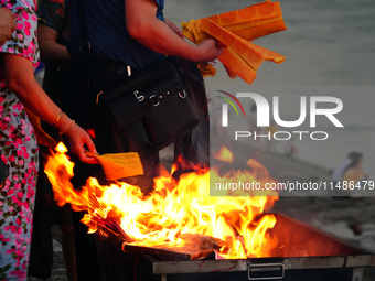 People are burning paper money to offer sacrifices to their ancestors during the Hungry Ghost Festival in Yichang, China, on August 16, 2024...