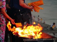 People are burning paper money to offer sacrifices to their ancestors during the Hungry Ghost Festival in Yichang, China, on August 16, 2024...