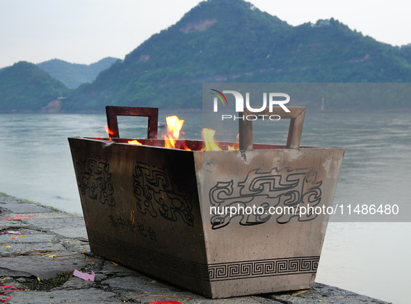 People are burning paper money to offer sacrifices to their ancestors during the Hungry Ghost Festival in Yichang, China, on August 16, 2024...