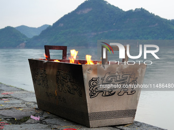 People are burning paper money to offer sacrifices to their ancestors during the Hungry Ghost Festival in Yichang, China, on August 16, 2024...