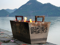 People are burning paper money to offer sacrifices to their ancestors during the Hungry Ghost Festival in Yichang, China, on August 16, 2024...