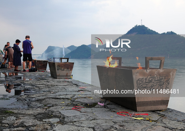 People are burning paper money to offer sacrifices to their ancestors during the Hungry Ghost Festival in Yichang, China, on August 16, 2024...