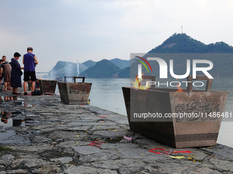 People are burning paper money to offer sacrifices to their ancestors during the Hungry Ghost Festival in Yichang, China, on August 16, 2024...