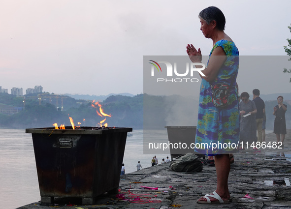 People are burning paper money to offer sacrifices to their ancestors during the Hungry Ghost Festival in Yichang, China, on August 16, 2024...