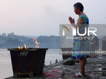 People are burning paper money to offer sacrifices to their ancestors during the Hungry Ghost Festival in Yichang, China, on August 16, 2024...