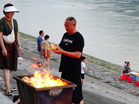 People are burning paper money to offer sacrifices to their ancestors during the Hungry Ghost Festival in Yichang, China, on August 16, 2024...