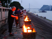 People are burning paper money to offer sacrifices to their ancestors during the Hungry Ghost Festival in Yichang, China, on August 16, 2024...