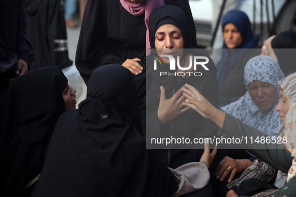 Palestinians are mourning their relatives, killed in an Israeli strike, at the Al-Aqsa Martyrs hospital in Deir el-Balah in the central Gaza...