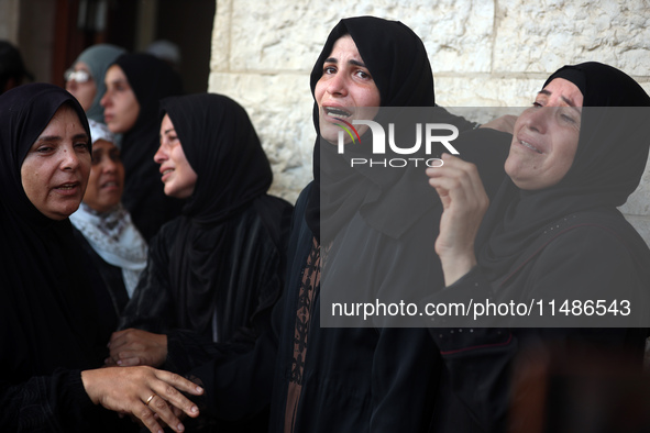 Palestinians are mourning their relatives, killed in an Israeli strike, at the Al-Aqsa Martyrs hospital in Deir el-Balah in the central Gaza...