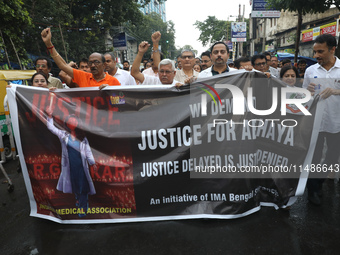 Medical professionals are holding placards and shouting slogans during a nationwide strike by doctors in a protest march against the recent...