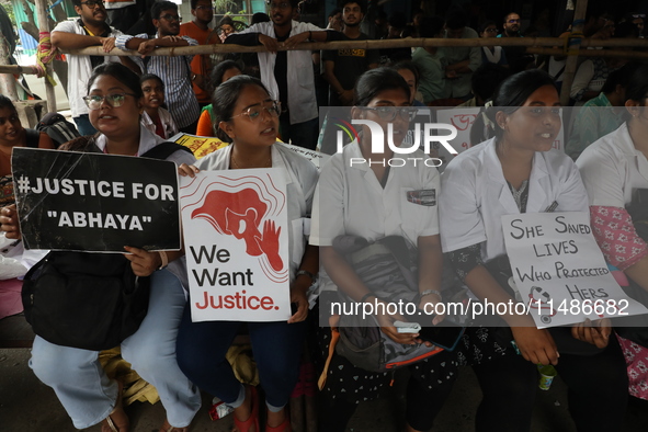 Medical professionals are holding placards protesting against the rape and murder of a PGT woman doctor at Government-run R G Kar Medical Co...