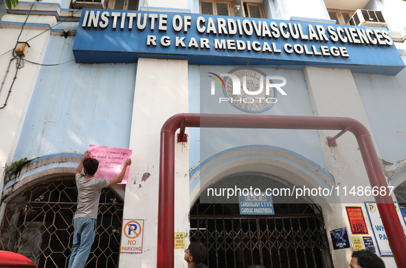 A medical student is pasting a poster on the wall inside the R G Kar Medical College and Hospital during a protest against the rape and murd...