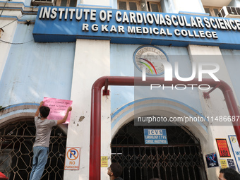 A medical student is pasting a poster on the wall inside the R G Kar Medical College and Hospital during a protest against the rape and murd...