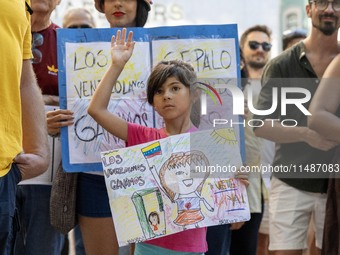 A child is carrying banners and placards and shouting political slogans during a rally in Praca de Restauradores in Lisbon, Portugal, on Aug...