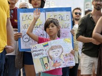 A child is carrying banners and placards and shouting political slogans during a rally in Praca de Restauradores in Lisbon, Portugal, on Aug...