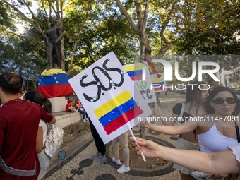 Several activists are carrying flags and banners and shouting political slogans during a rally in Praca de Restauradores in Lisbon, Portugal...