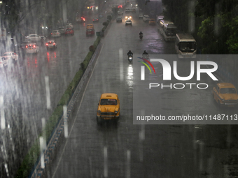 A yellow ambassador taxi is moving slowly following heavy monsoon rains in Kolkata, West Bengal, India, on August 17, 2024. (