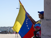 A person is holding a Venezuelan flag to protest the recent election results in Venezuela during a rally at Commerce Square in Lisbon, Portu...