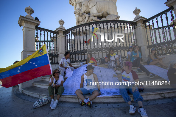 People are holding the voting report ''Actas'' during a rally at Commerce Square in Lisbon, Portugal, on August 17, 2024. Opponents to the r...