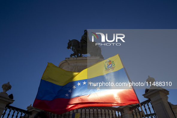 A person is holding a Venezuelan flag during a rally at Commerce Square in Lisbon, Portugal, on August 17, 2024. Opponents to the regime of...