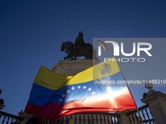 A person is holding a Venezuelan flag during a rally at Commerce Square in Lisbon, Portugal, on August 17, 2024. Opponents to the regime of...