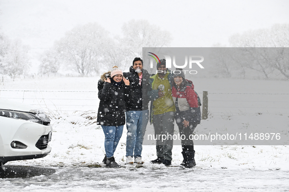 People are posing in front of a snow-covered farm during heavy snowfall in Springfield, in the Selwyn District of Canterbury, in the South I...