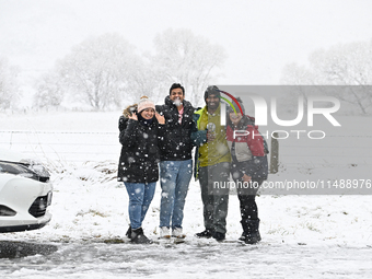 People are posing in front of a snow-covered farm during heavy snowfall in Springfield, in the Selwyn District of Canterbury, in the South I...