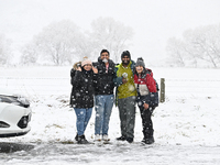 People are posing in front of a snow-covered farm during heavy snowfall in Springfield, in the Selwyn District of Canterbury, in the South I...