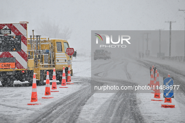 A road is being closed with a stop sign during heavy snowfall in Springfield, in the Selwyn District of Canterbury, in the South Island, New...